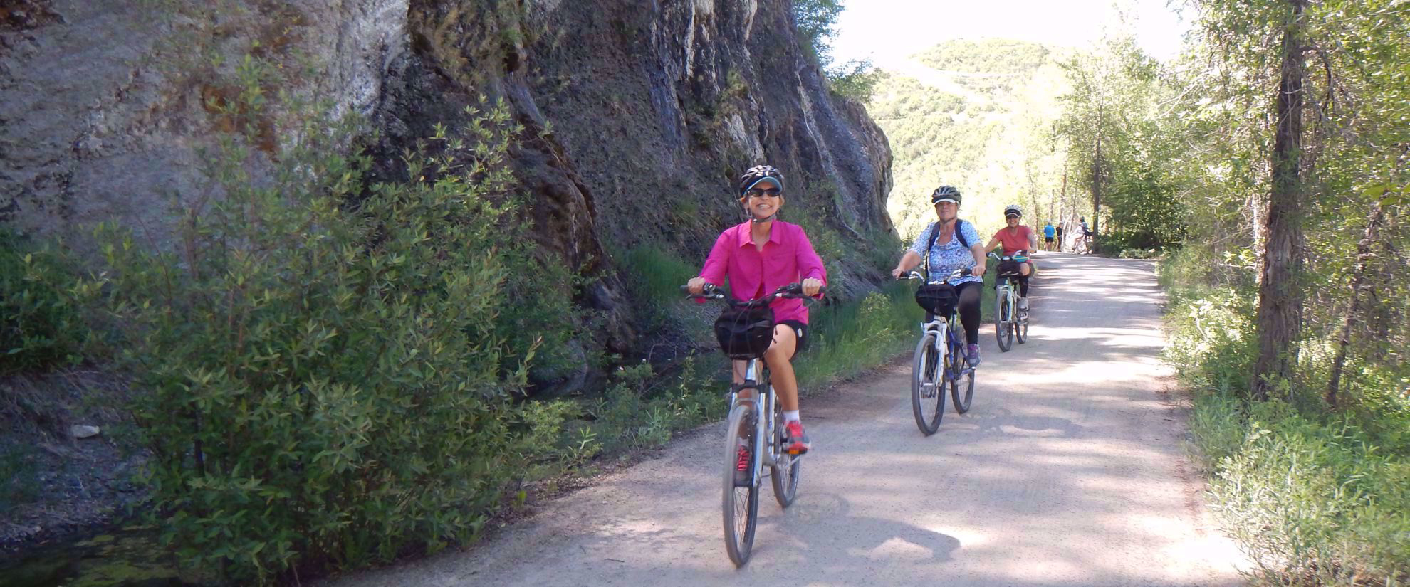 women smiling riding bikes on group tour in colorado