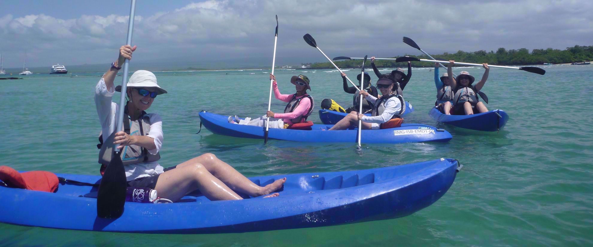 women kayaking in water around the galapagos on group travel tour