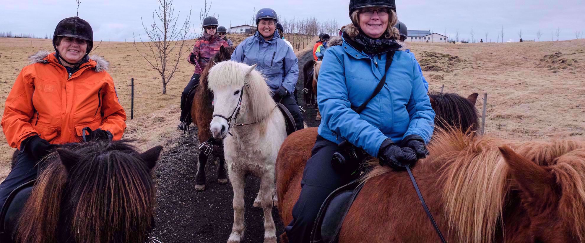 women's travel group riding ponies in iceland