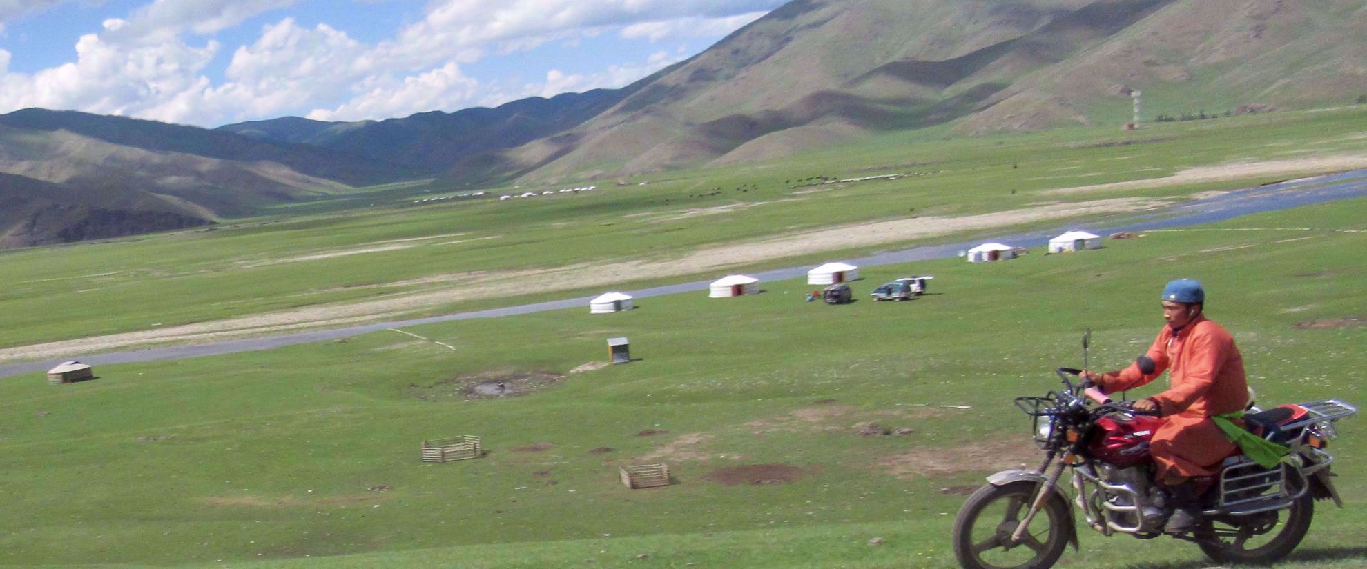 man riding motorcycle in rural mongolia