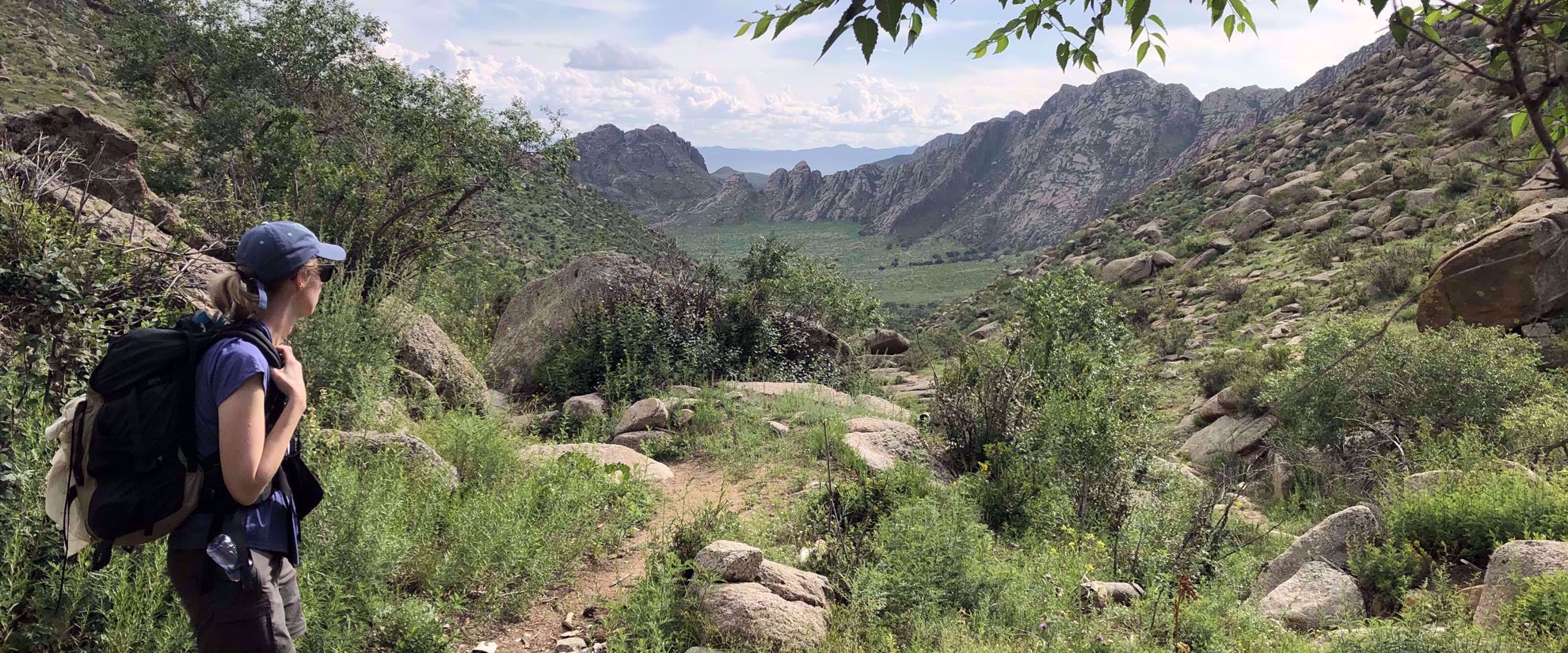 woman with backpack hiking in mongolia