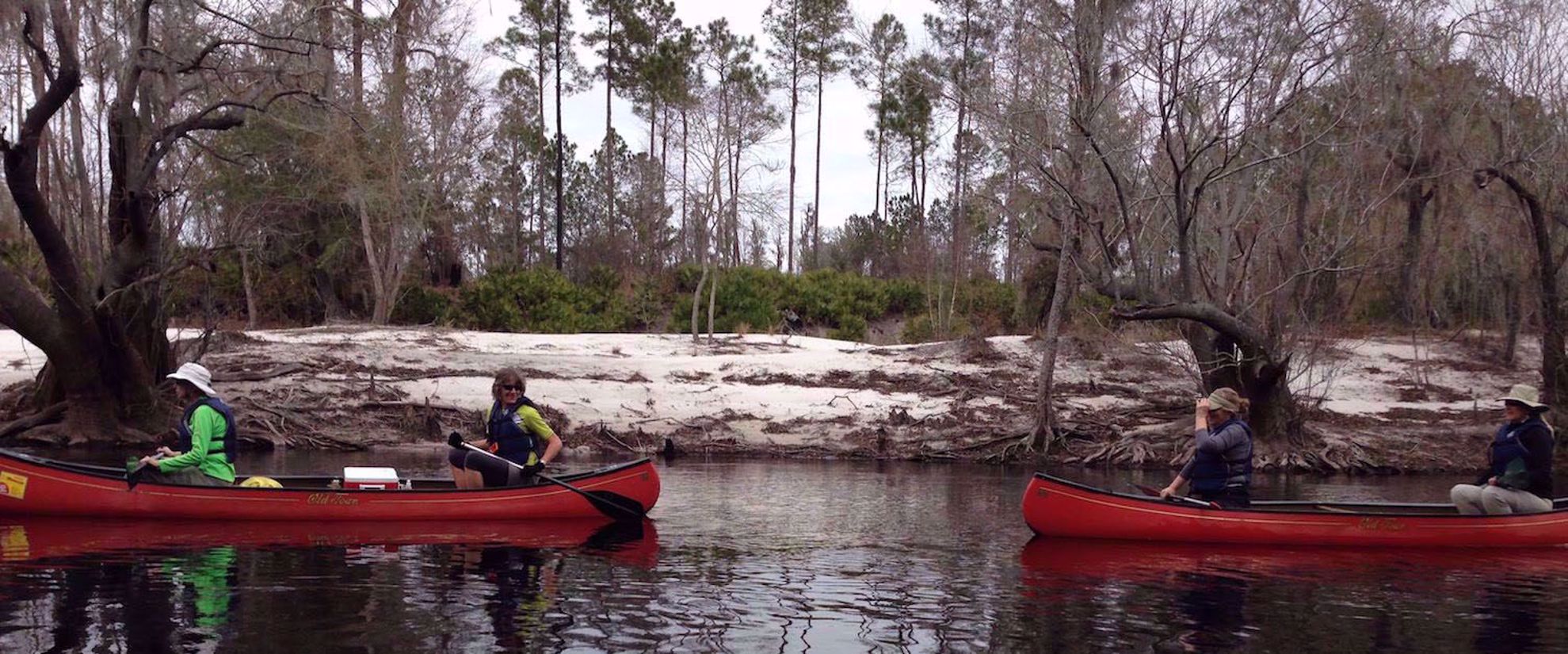 women laughing and smiling in red kayaks on suwannee river