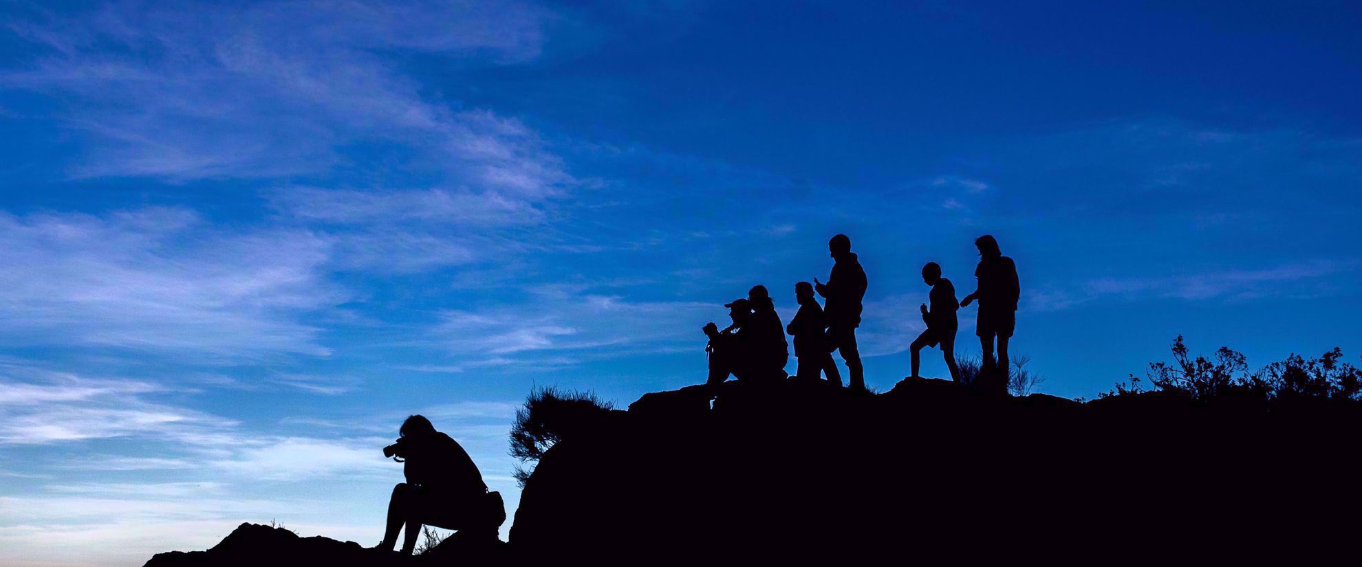 silhouette of photographers on ridge