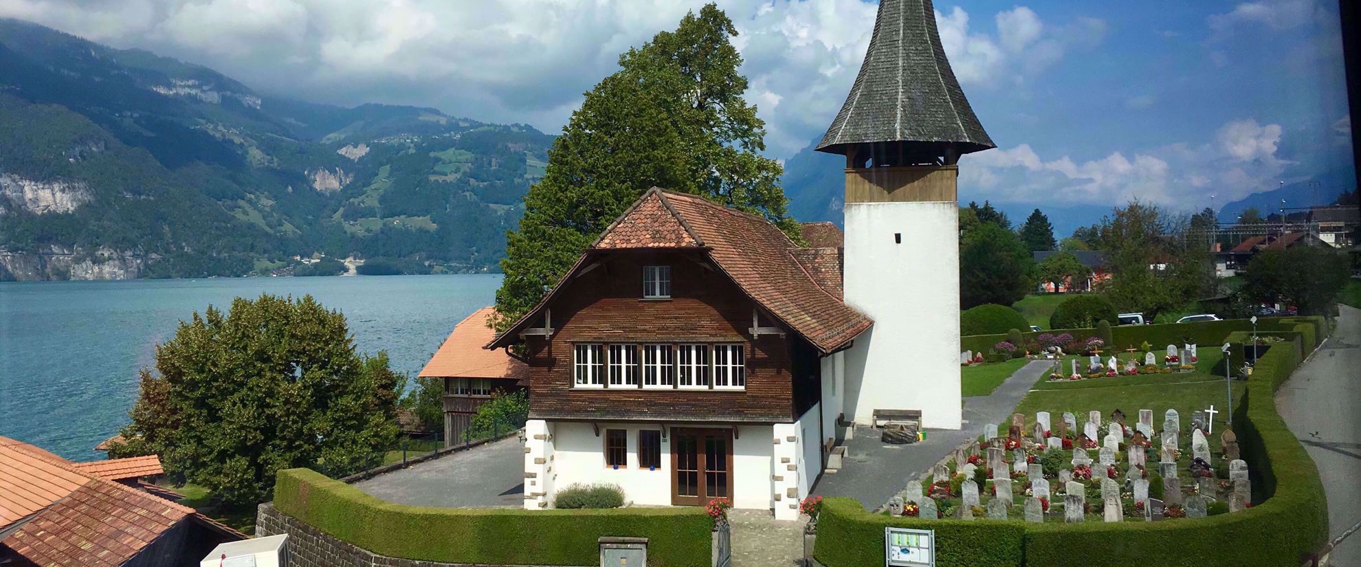 quaint swiss cemetery next to lake and mountains in alps