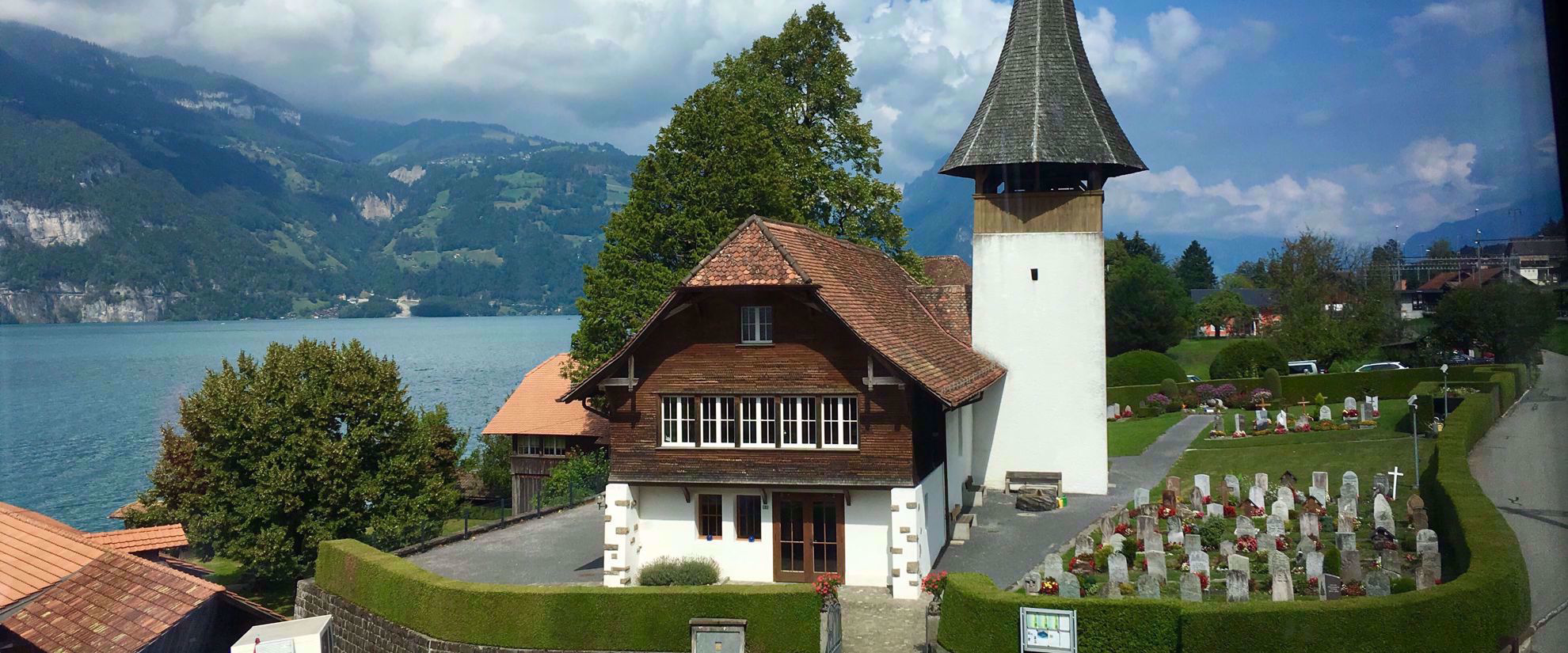 quaint swiss cemetery next to lake and mountains in alps