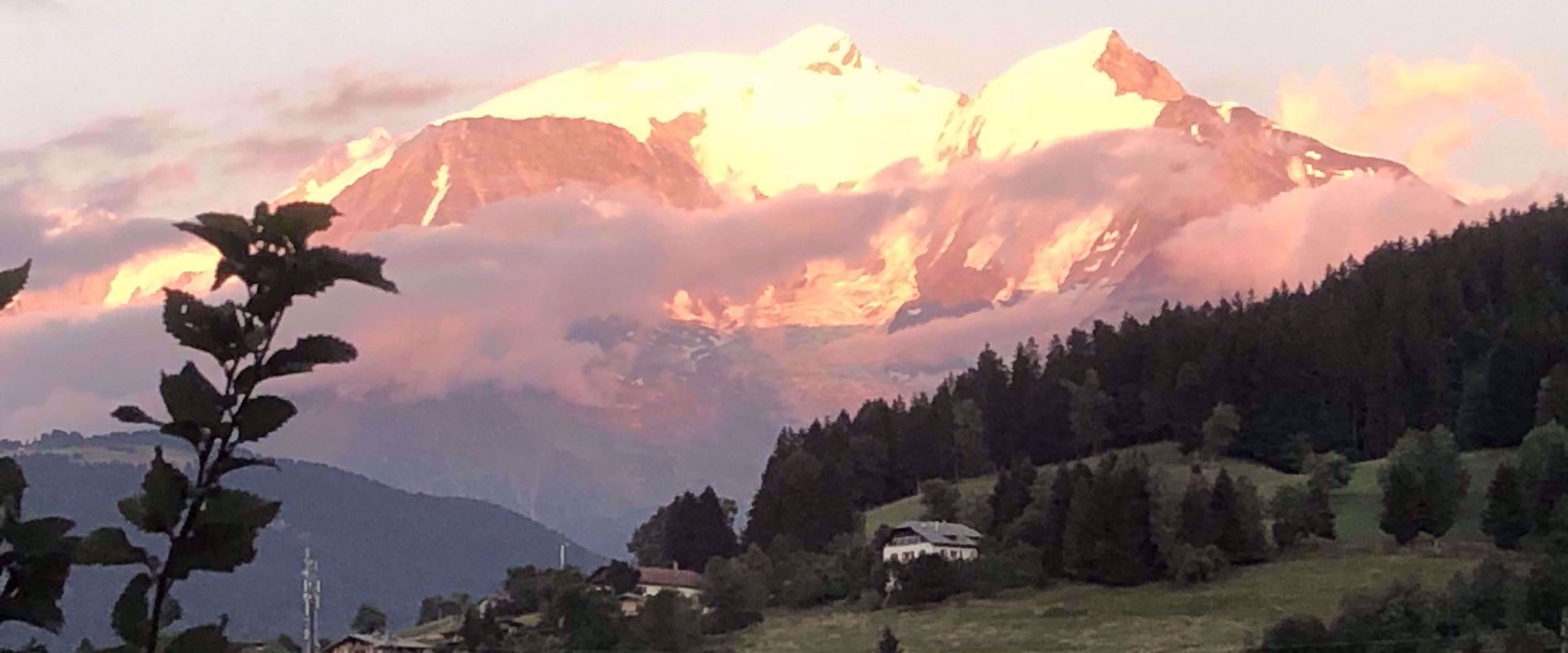 sun shining on snow covered mountains in swiss alps