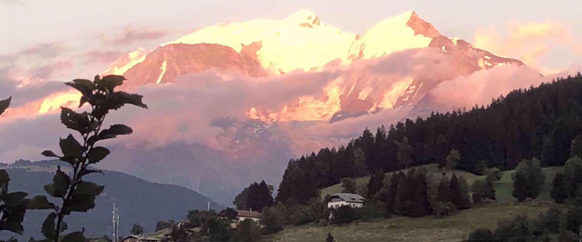 sun shining on snow covered mountains in swiss alps