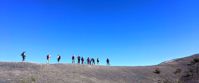 women on a hike on a ridge desert photo. bright blue sky in background