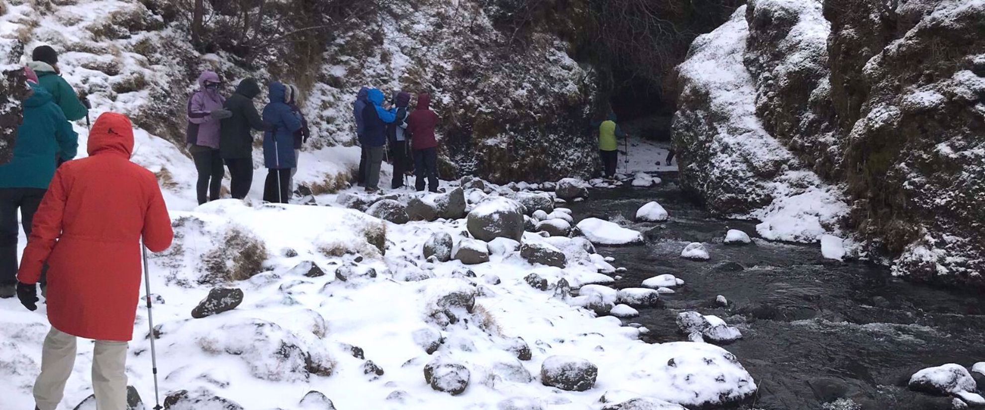 women hiking to frozen waterfall iceland
