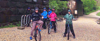 women in raincoats on bikes smiling on bike path in harpers ferry